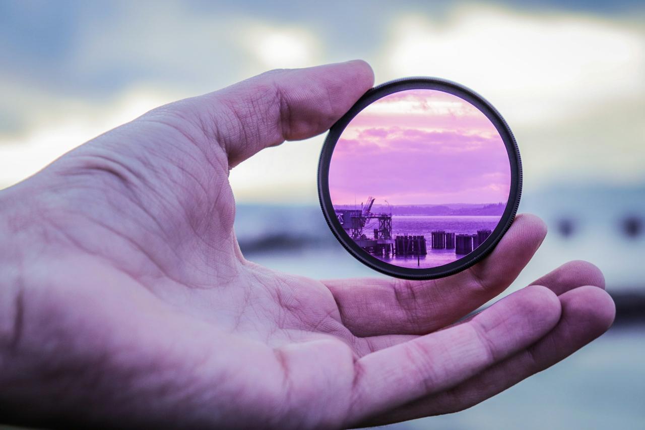 A hand holding a lens that reveals a transformed view
