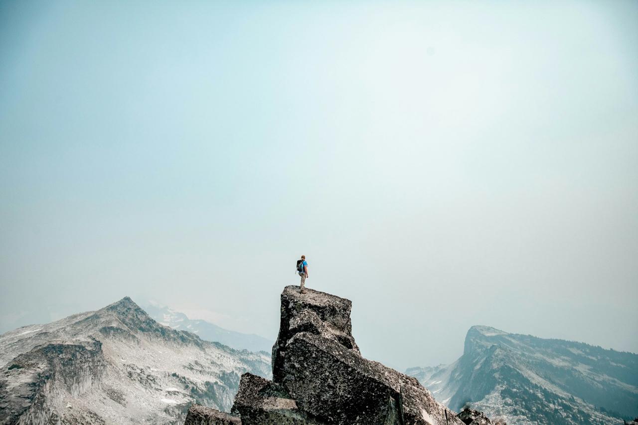 A person standing at the summit of a mountain